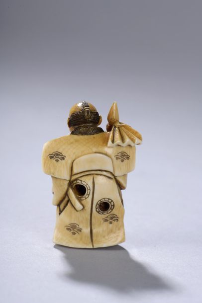 null JAPON, début du XXe siècle. 
Netsuke signé représentant un homme debout tenant...