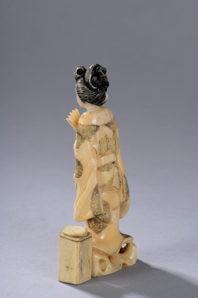 null JAPON, milieu du XXe siècle. 
Okimono représentant une geisha debout tenant...