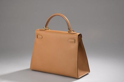 null 
HERMÈS
Sac modèle "Kelly" en cuir grainé gold, piqûres sellier, les attaches...