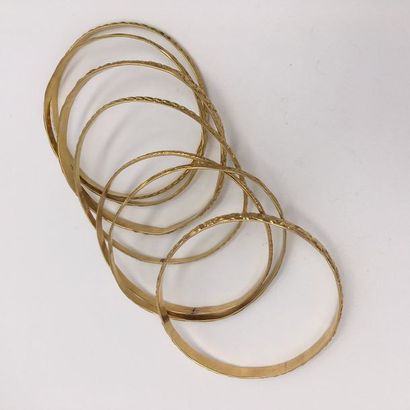 null Semainier composé de sept bracelets rigides en or jaune (750 millièmes) ciselé...