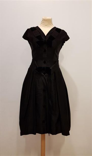 null Anonyme
Robe en taffetas noir à noeuds de velours noir, années 50, T.36 environ...