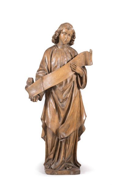 null Carved walnut angel, sketched back. Standing, holding a phylactery in his hands,...