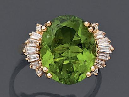 null Yellow gold ring (750 ‰) set with an oval-shaped peridot weighing approximately...