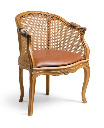 null A natural wood (stripped) cane armchair, moulded and carved with flowers, the...