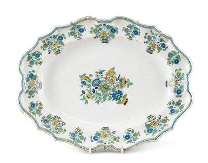 MOUSTIERS An earthenware oval dish with polychrome decoration of flowers in the center...