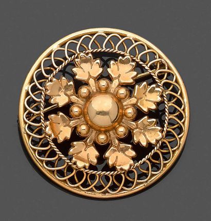 null BROCHE circulaire en or jaune (750‰) ajouré, torsadé et boulé, à motifs de feuilles.
Travail...