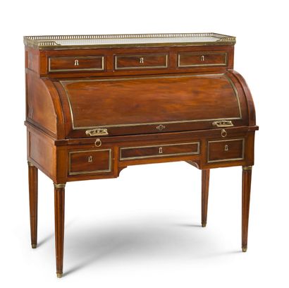 null A CYLINDER DESK in mahogany and mahogany veneer decorated with brass framing...