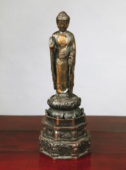 null Statuette de bouddha debout sur le lotus en bronze à patine brune et laque or....