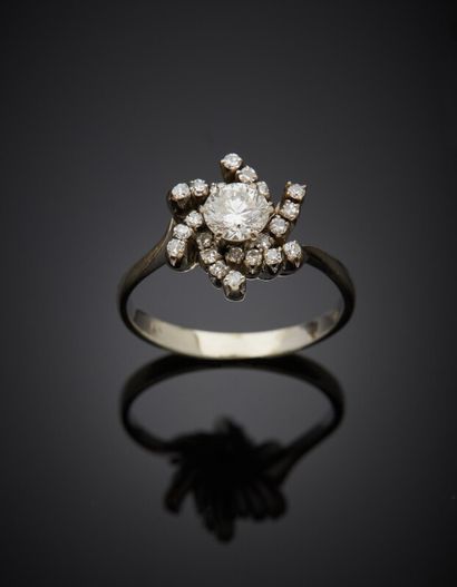  BAGUE « fleur » en or gris (750) serti d'un diamant taille brillant entouré de petits...
