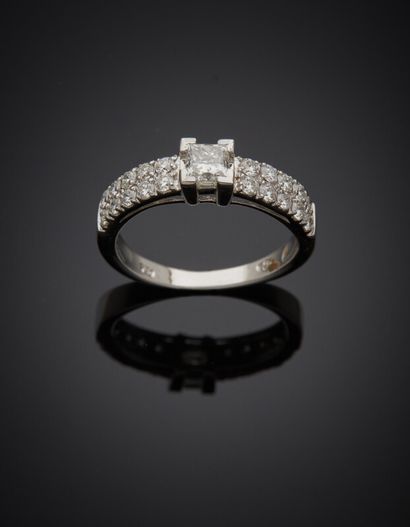  BAGUE « bandeau » en or gris (750) serti d'un diamant taille princesse épaulé d'alignements...