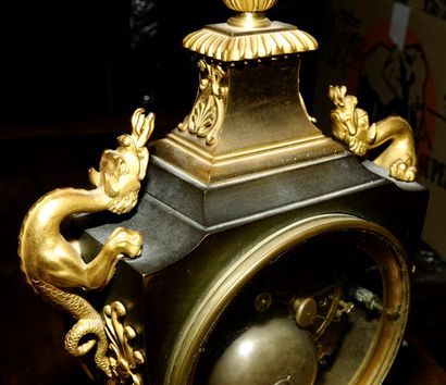 null 
Pendule en forme d'urne en bronze doré et bronze patiné à décor de palmettes...