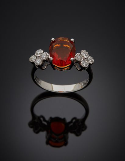 null White gold ring (750‰) adorned with an oval-shaped fire opal, shouldered by...