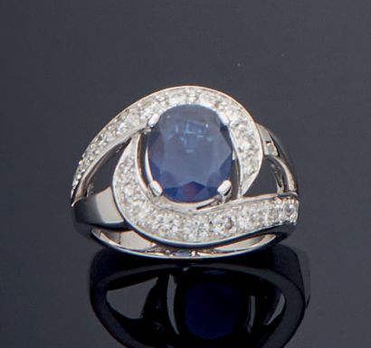 null BAGUE «sinueuse» en or gris (750‰) ajouré, centré d'un saphir pesant 2,51 carats,...