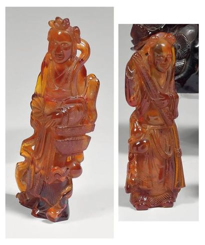 null Deux statuettes en ambre, personnage debout tenant un rouleau et jeune femme...