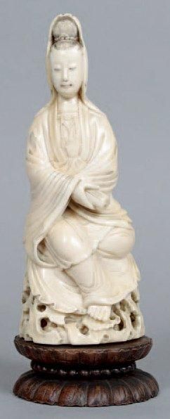 null Statuette de Guanyin en ivoire à patine jaune, assis sur un rocher et tenant...