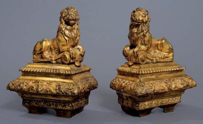 null Paire de chenets en bronze ciselé et doré représentant des lions couchés sur...
