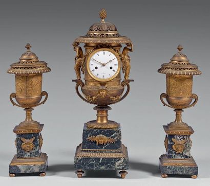 null Garniture de cheminée: - La pendule en forme de vase présente un cadran à la...