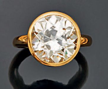  Bague solitaire en or jaune 18k sertie clos d’un diamant de taille coussin carré...