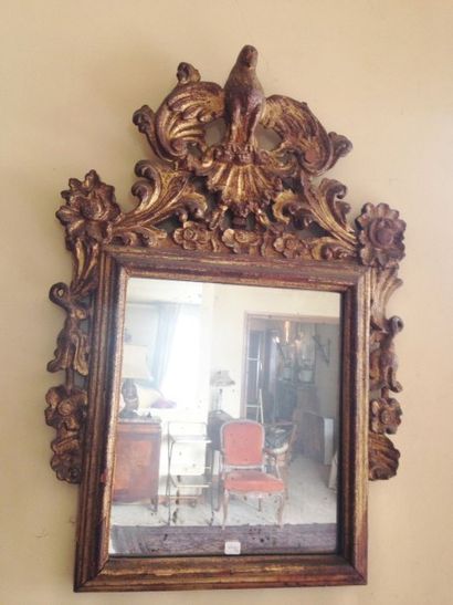 Un miroir à fronton en bois doré à décor...
