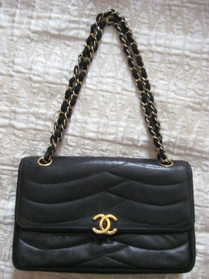 CHANEL Sac en cuir noir matelassé, fermeture siglé sur rabat, chaine de métal entrelacé...