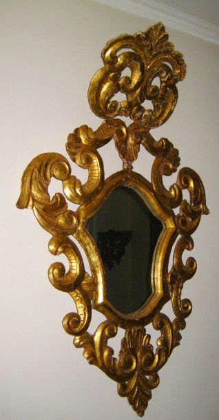 null Miroir écusson en bois doré et sculpté de larges volutes ajourées et feuillagées,...