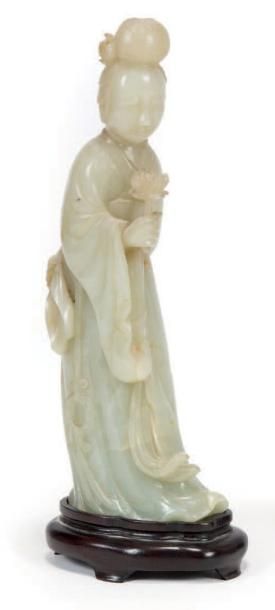 CHINE - XIXe siècle Statuette de jeune femme debout en néphrite céladon tenant dans...