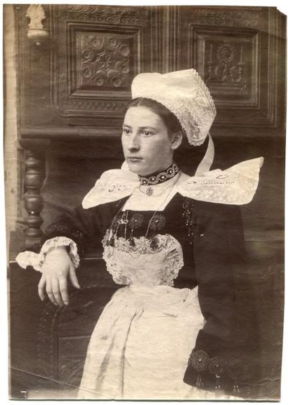 null Photographe non identifié. Portrait de femme en appui sur un buffet, vers 1890....