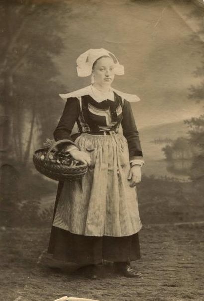 null Photographe non identifié. Portrait de femme au panier de victuaille, vers 1880....