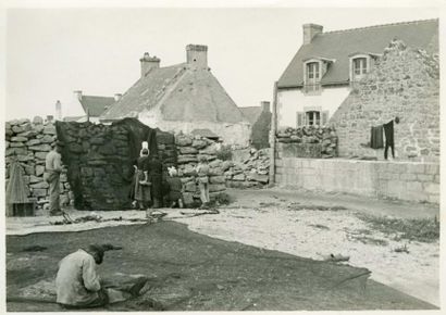 null Photographe non identifié. Saint Guénolé, famille bretonne ravaudant et mettant...