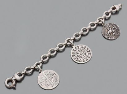 null Bracelet en argent à maillons ronds agrafés retenant trois médailles: un Christ...