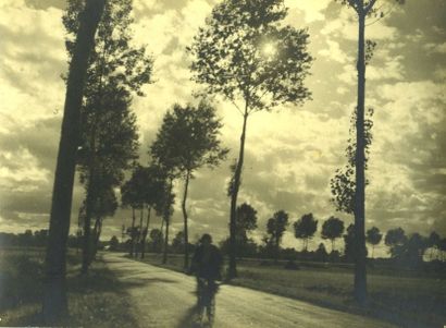 null Photographe non identifié. Cycliste sous un ciel dramatique, vers 1950. Tirage...