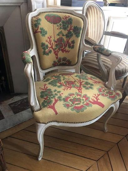 null Un fauteuil cabriolet en bois peint crème 
Style Louis XV
Tapisserie à fond...