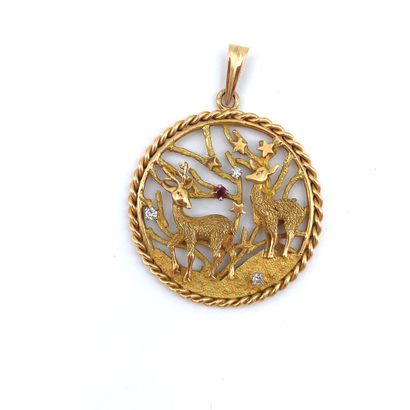 *Collier *COLLIER en or (750‰) retenant un médaillon rond à décor ajouré de cerfs...