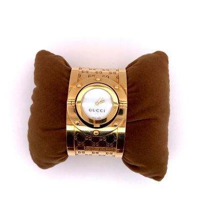 GUCCI GUCCI, modèle Twirl 

BRACELET MONTRE manchette en or (750‰), lunette ronde...