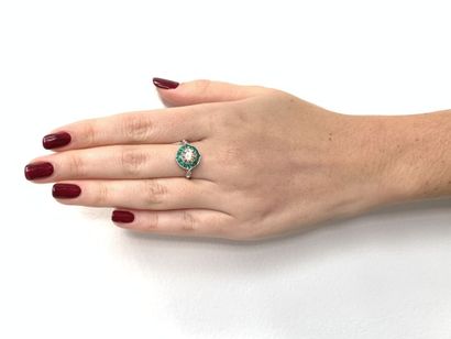 BAGUE en or gris, diamants et émeraudes White gold (750‰) ring centered with a brilliant-cut...
