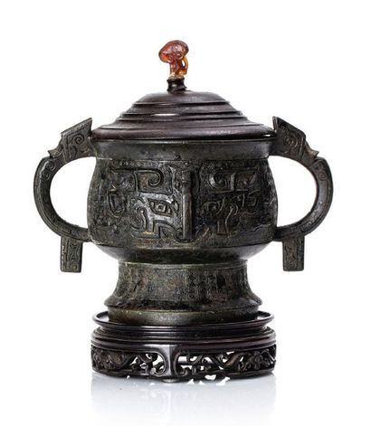 CHINE XVIIIe siècle Vase gui en bronze de patine brune, à décor de masques de taotie,...