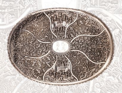 CHINE DU SUD-VIETNAM DEBUT XXe SIECLE Oval tray on four legs, in silver, repouss...