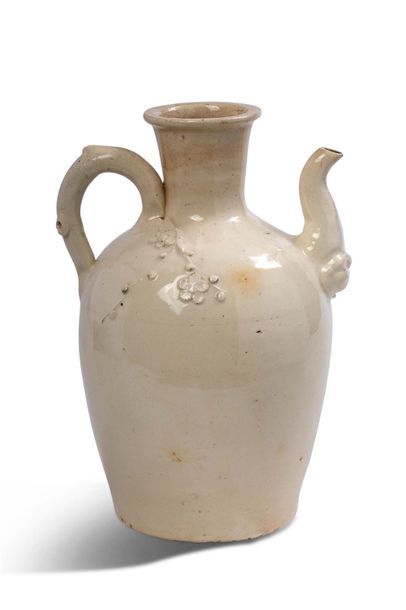 CHINE XIIIe-XIVe SIÈCLE Cream-glazed ceramic jug, with a high and long neck, a pouring...