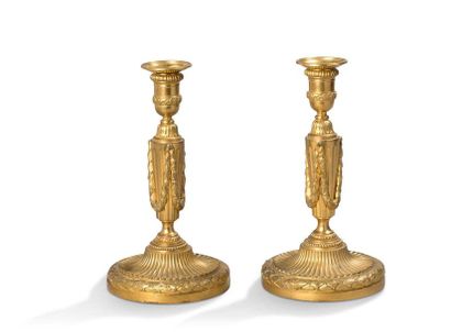 null Pair of FLAMBEAUX in chased and gilded bronze. The fluted truncated conical...