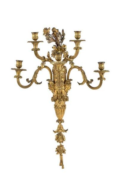 null SUITE DE QUATRE APPLIQUES
À CINQ BRAS DE LUMIÈRE en bronze ciselé et doré. Les...