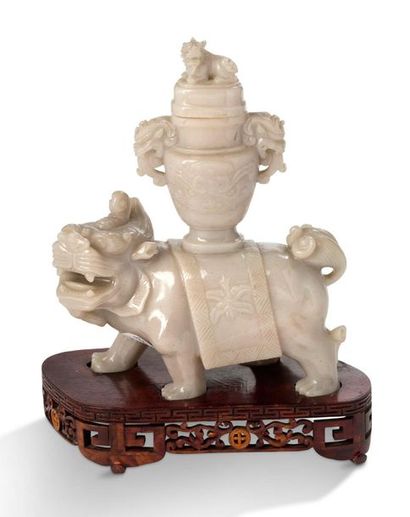 CHINE Honan jade group representing a Qilin, head turned to his left, carrying a...
