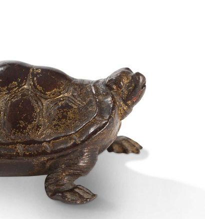 CHINE Bronze turtle with traces of gold lacquer on a brown background.
L. 9 cm (Shock...