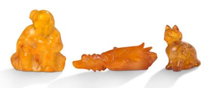 CHINE Lot comprenant trois petits objets en ambre, dont un chou, un chat, et un sage...