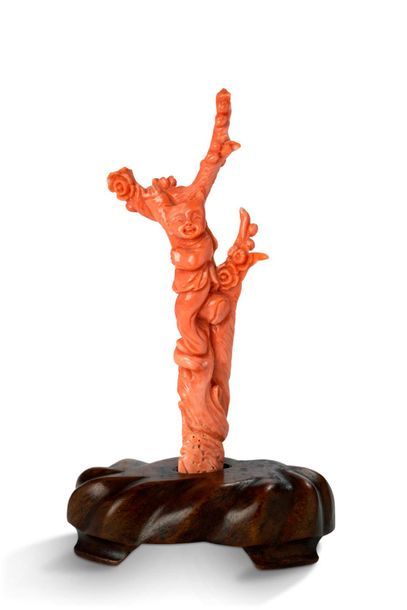 CHINE Small statuette in light red coral, decorated with a child on a prunus.
H....