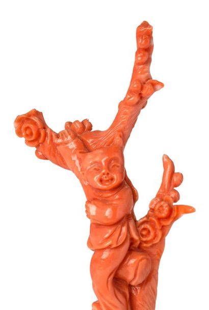 CHINE Petite statuette en corail rouge clair, à décor d'un enfant sur un prunus.
H....