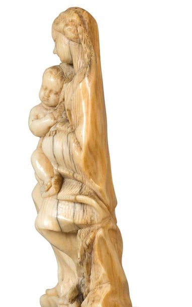 null VIERGE À L’ENFANT
en ivoire sculpté en ronde-bosse. Assise,
la Vierge serre...