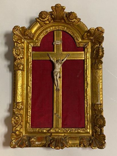 Christ en ivoire sculpté dans un cadre en bois sculpté et doré à fronton à décor