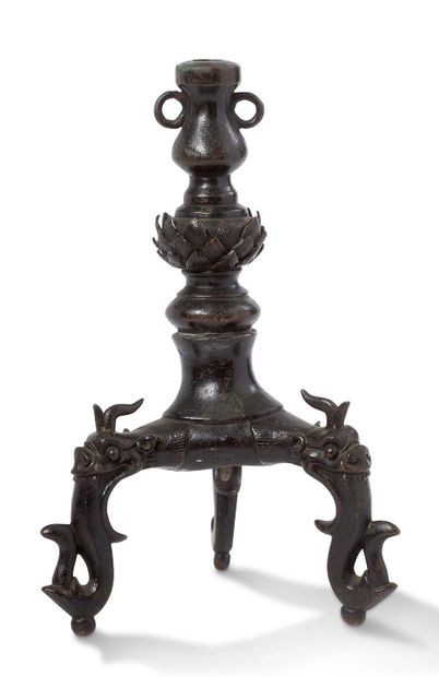 CHINE 
A bronze tripod candlestick, the legs spat out by Qilin heads, the upper part...