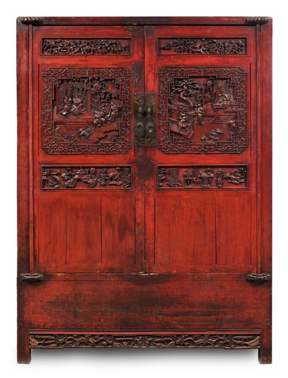 CHINE DU SUD 
Large red lacquered wood cabinet with two doors, carved in relief with...