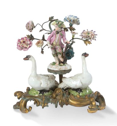 null 瓷器组是迈森风格和镀金青铜形成的两只天鹅，框住一个年轻的园丁，手持铲子，在一个镀金青铜的阳台上，上面有玫瑰花装饰物，上面有一枝饰有瓷花的树枝。十九世纪...